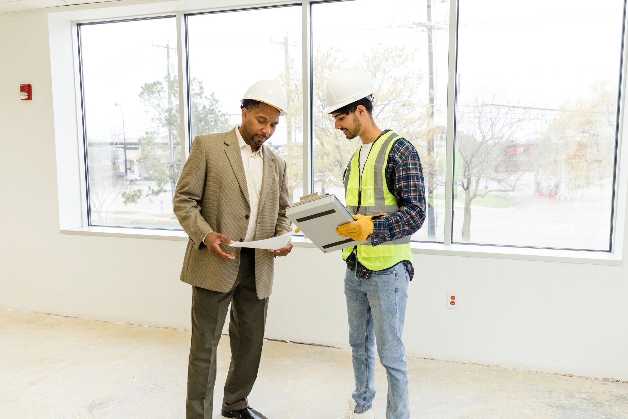 Inspector and business owner comparing notes during a project meeting