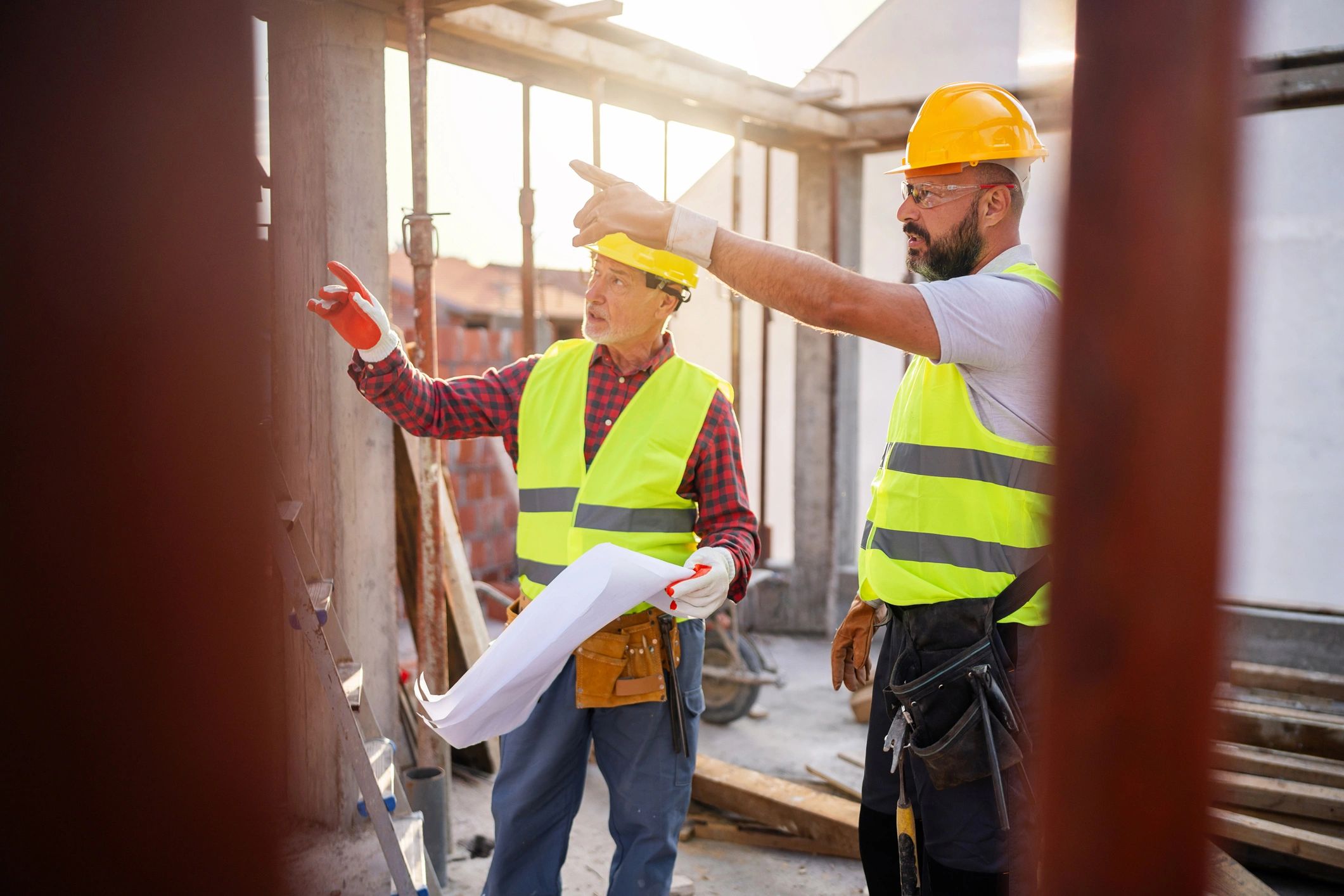 Architect and contractor reviewing permit documents on a construction site